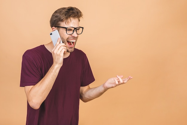 Giovane arrabbiato che grida sul telefono cellulare isolato