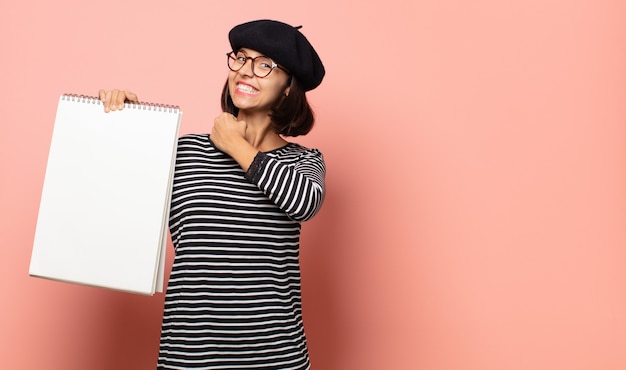 Giovane artista donna che si sente felice, positiva e di successo, motivata quando affronta una sfida o celebra buoni risultati