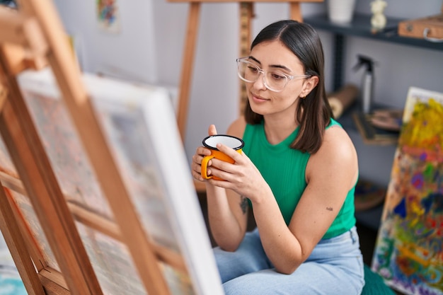 Giovane artista ispanico della donna che beve caffè allo studio di arte