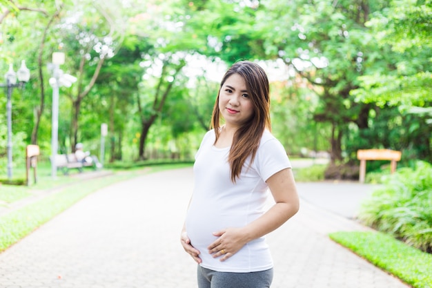 Giovane Asia incinta nel bellissimo giardino