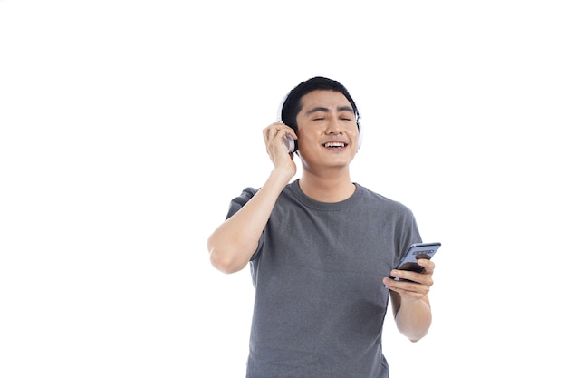 Giovane asiatico che ascolta la musica e che canta sul suo telefono