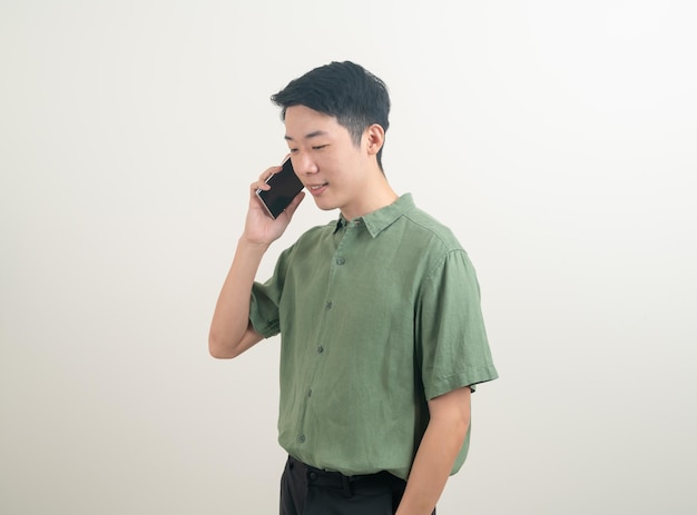 giovane asiatico che usa o parla smartphone e telefono cellulare su sfondo bianco