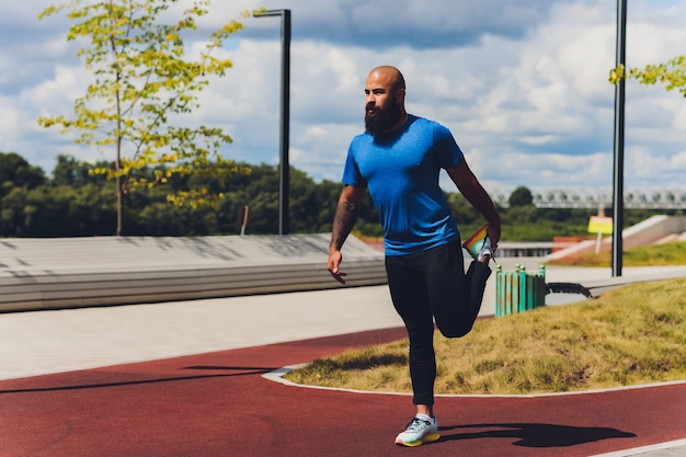 Giovane atleta che corre veloce all'aperto. Indossare indumenti sportivi, fare un passo ampio, dimostrare uno stile di vita sano, campo lungo.