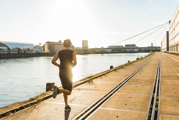 Giovane atleta che fa jogging in città al fiume