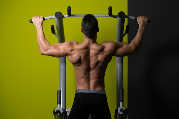 Giovane atleta che fa Pull Ups ChinUps in palestra