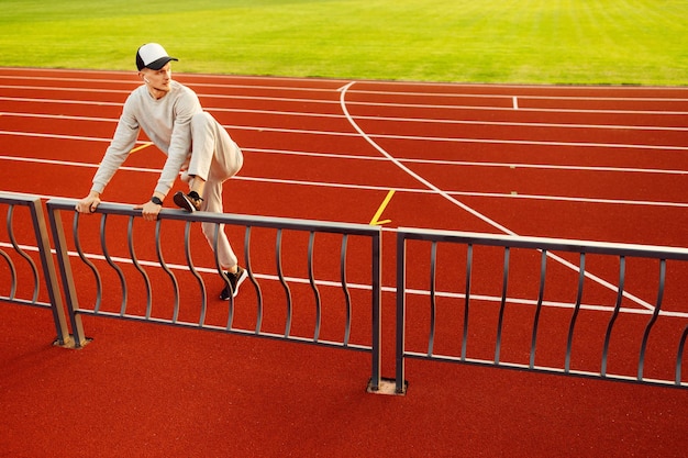 Giovane atleta che fa stretching prima di correre allo stadio Foto di alta qualità