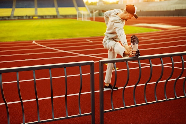 Giovane atleta che fa stretching prima di correre allo stadio Foto di alta qualità