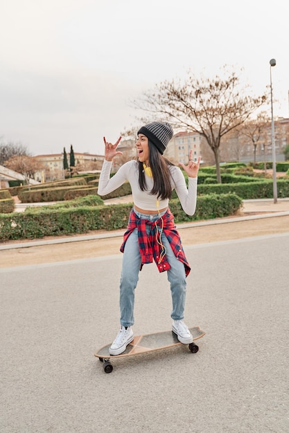 Giovane atleta che guida uno skateboard sulla strada per il tempo libero e il concetto di sport