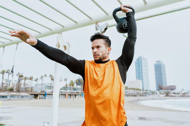 Giovane atleta che si allena al mattino sulla spiaggia in palestra