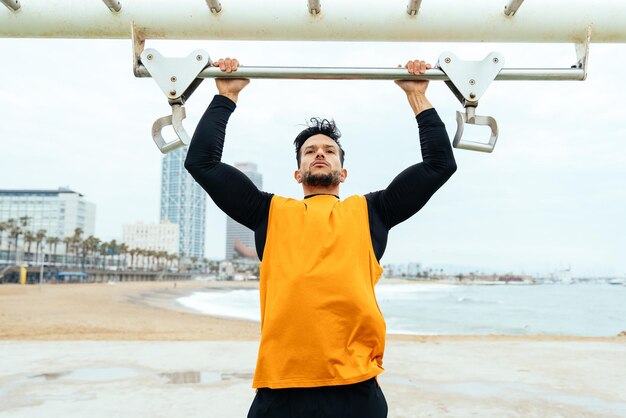 Giovane atleta che si allena al mattino sulla spiaggia in palestra