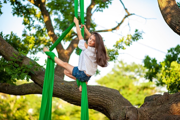 Giovane atleta di ginnastica arial e vista sull'albero