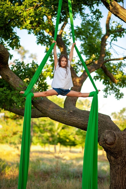 Giovane atleta di ginnastica arial e vista sull'albero