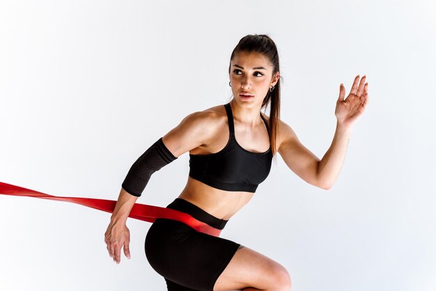 Giovane atleta femminile che si allena in palestra utilizzando attrezzature sportive