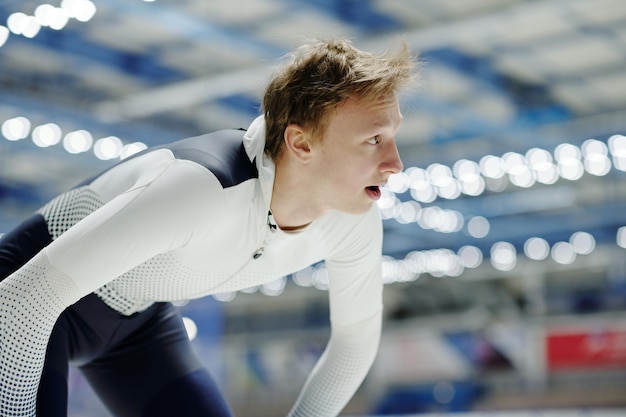 Giovane atleta maschio biondo in uniforme sportiva in attesa del segnale di avvio