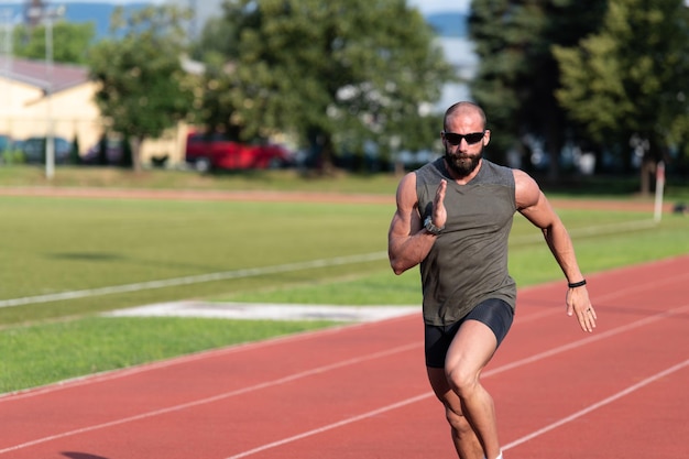 Giovane atleta maschio che corre sulla pista