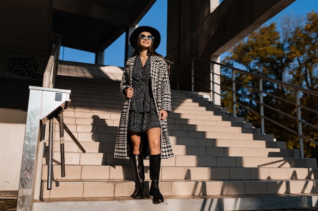 Giovane attraente che cammina in autunno con il cappotto.