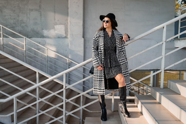 Giovane attraente che cammina in autunno con il cappotto.
