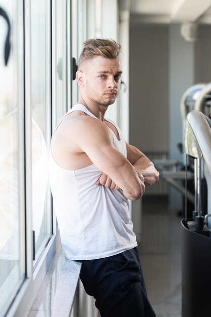 Giovane attraente che riposa in palestra dopo l'esercizio