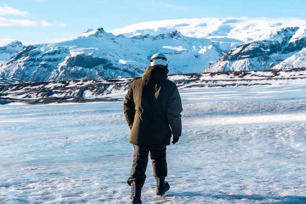 Giovane avventuroso che cammina sul ghiacciaio Vatnajokull in inverno in Islanda