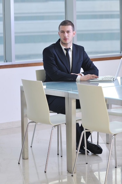 giovane avvocato uomo d'affari con laptop da solo nella grande sala conferenze luminosa