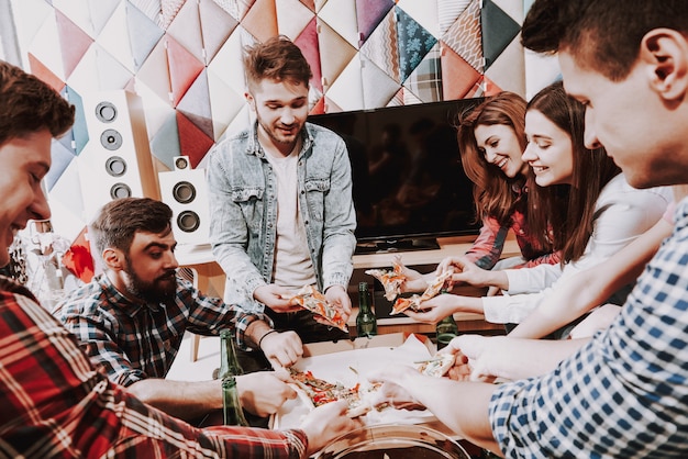 Giovane Azienda Affamata Che Mangia Pizza In Una Festa.