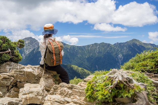 Giovane backpacker femmina seduta sulla scogliera