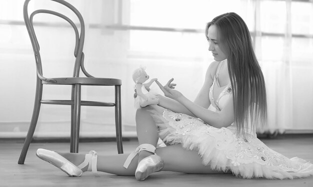 Giovane ballerina su un riscaldamento. La ballerina si sta preparando per esibirsi in studio. Una ragazza in abiti da ballo e scarpe impasta da corrimano.