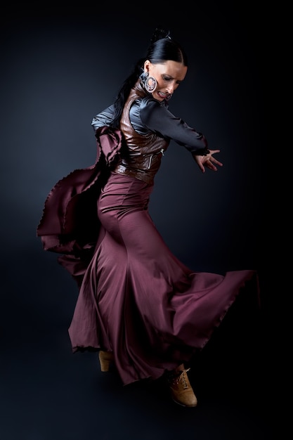 Giovane ballerino di flamenco in bel vestito su sfondo nero.