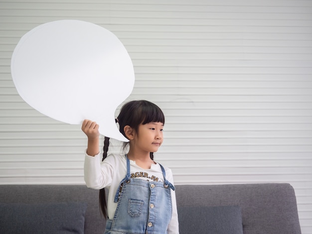 Giovane bambina asiatica che tiene un segno in bianco