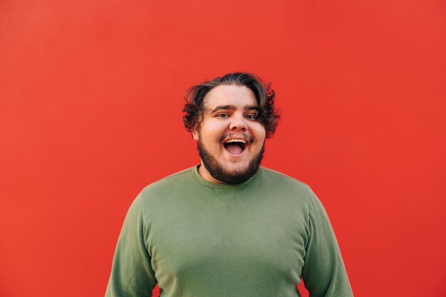 giovane barbuto con un ampio sorriso a trentadue denti che si sente felice e positivo guardando la telecamera