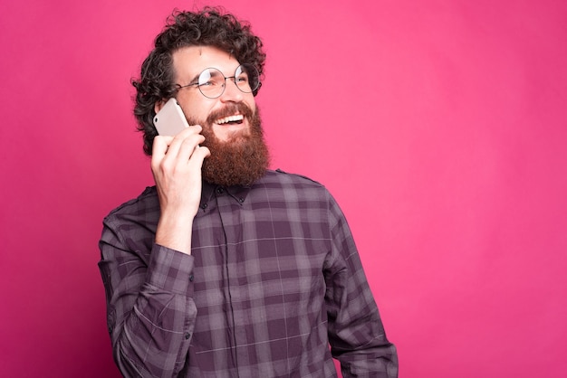 giovane barbuto sta parlando al suo telefono