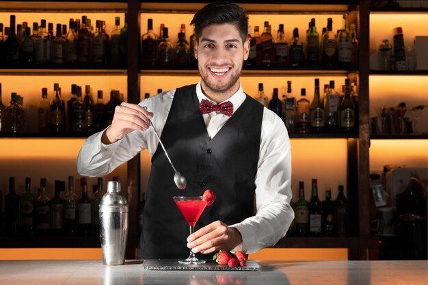 Giovane barista che serve un cocktail in un night club