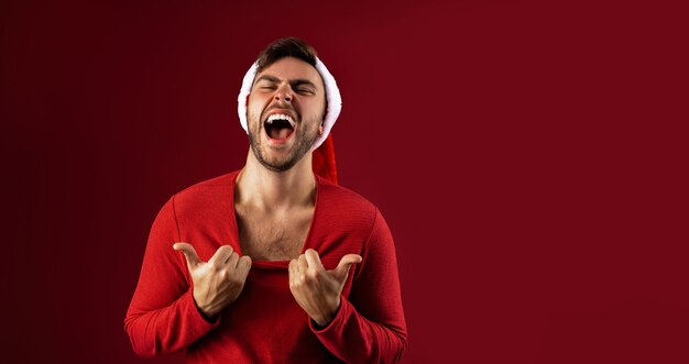 Giovane bel ragazzo con cappello di Babbo Natale