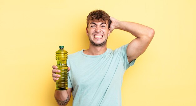 Giovane bell'uomo che si sente stressato, ansioso o spaventato, con le mani sulla testa. concetto di olio d'oliva