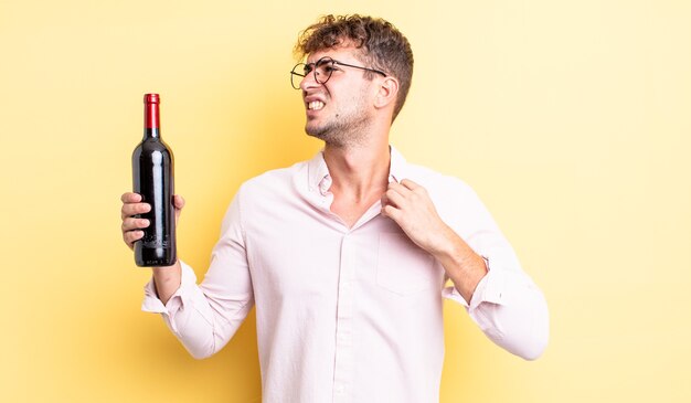 Giovane bell'uomo che si sente stressato, ansioso, stanco e frustrato. concetto di bottiglia di vino