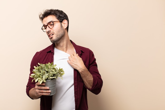 Giovane bell'uomo che si sente stressato, ansioso, stanco e frustrato, tira il collo della camicia, sembra frustrato dal problema