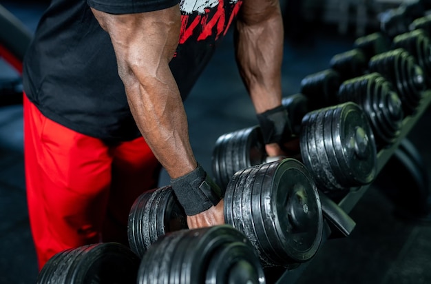 Giovane bell'uomo che solleva pesi pesanti Uomo muscoloso forte dall'alto allenamento in palestra