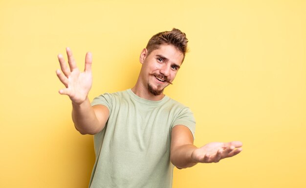 Giovane bell'uomo che sorride allegramente dando un caldo, amichevole, amorevole abbraccio di benvenuto, sentendosi felice e adorabile. strano concetto di baffi