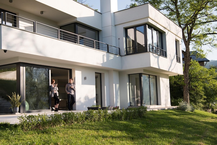 Foto giovane bella coppia bella godendo il caffè del mattino sulla porta della loro villa di lusso