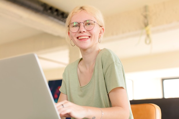 Giovane bella donna a casa che usa un laptop