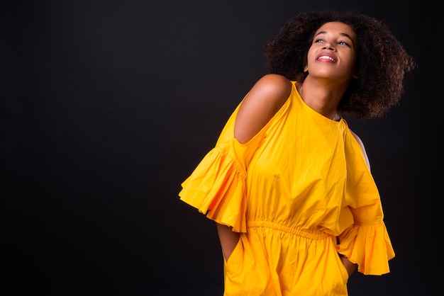 giovane bella donna africana con capelli afro sul nero