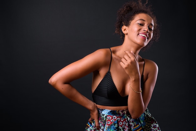 giovane bella donna africana con capelli afro sul nero