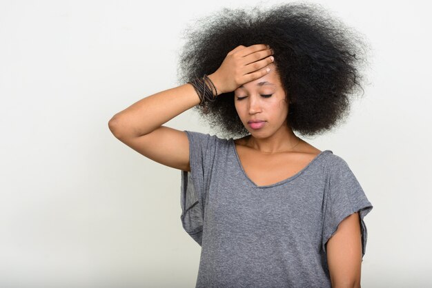 giovane bella donna africana con i capelli afro su bianco