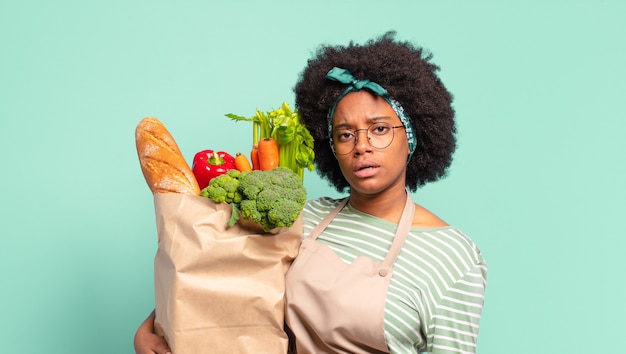 Giovane bella donna afro che si sente perplessa e confusa