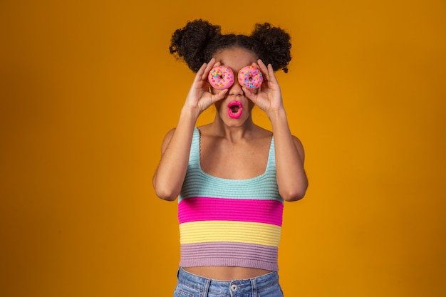 Giovane bella donna afro con una ciambella