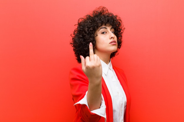 Giovane bella donna afro sentirsi arrabbiata, infastidita, ribelle e aggressiva, lanciando il dito medio, contrattaccando