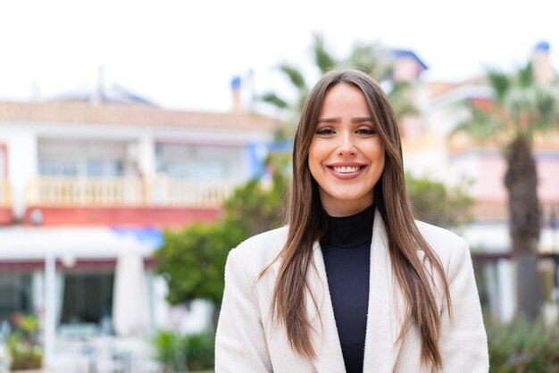 Giovane bella donna all'aperto con espressione felice