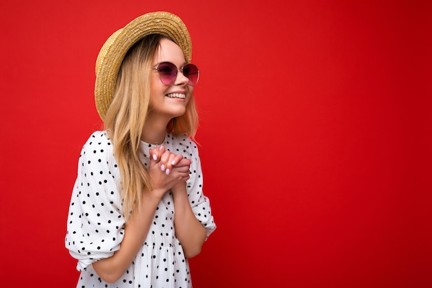 Giovane bella donna alla moda donna in abito estivo casual e cappello di paglia e occhiali da sole positivi