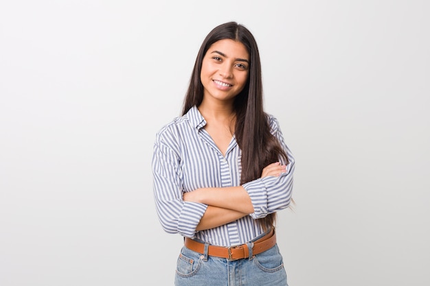 Giovane bella donna araba che si sente fiduciosa, incrociando le braccia con determinazione.