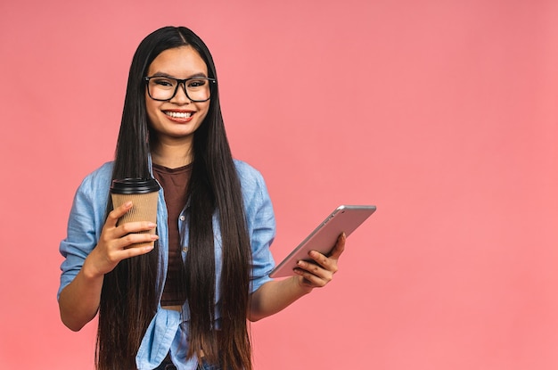 Giovane bella donna asiatica che utilizza tablet gadget computer ipad Concetto di stile di vita isolato su sfondo rosa